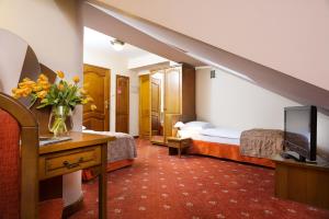 a hotel room with two beds and a television at Hotel Regent in Kraków