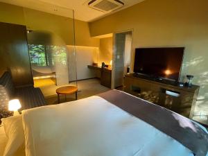 a hotel room with a bed and a flat screen tv at Ame no Hi to Yuyake-Adult Only in Chitose