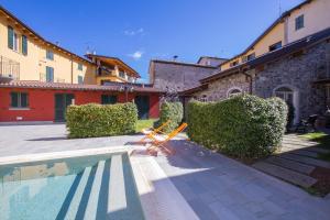 basen przed budynkiem z dwoma pomarańczowymi krzesłami w obiekcie Bellagio Spiaggia Due and Balcone w mieście Bellagio
