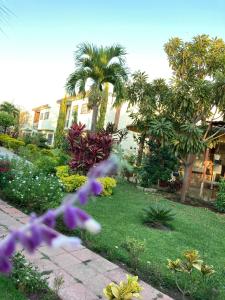 a garden with palm trees and purple flowers at Quinta Doña Carlota in Chiconcuac