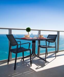 d'une table et de chaises sur un balcon donnant sur l'océan. dans l'établissement Zen Vacation Rentals Hyde Ocean Front 3-Bedroom Paradise, à Hollywood
