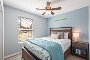 um quarto com uma cama e uma ventoinha de tecto em Surfside Cottage near Navarre Beach em Navarre