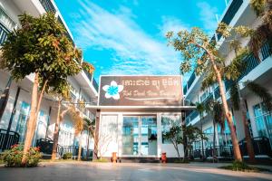 a sign in front of a building with palm trees at Koh Dach View Boutique Hotel in Phnom Penh