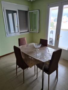 una sala da pranzo con tavolo, sedie e finestra di Center City Apt a Chio (Chios)