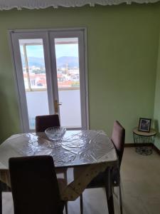 a dining room table with chairs and a large window at Center City Apt in Chios