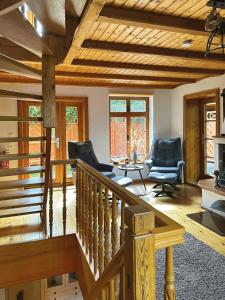 ein Wohnzimmer mit einer Holztreppe und Stühlen in der Unterkunft Ferienhaus Nicole in Quedlinburg