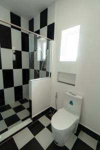 a bathroom with a toilet and black and white checkered floor at Koh Dach View Boutique Hotel in Phnom Penh