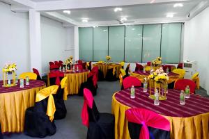 un salón de banquetes con mesas y sillas rojas y amarillas en Relax Guest House en Batapola