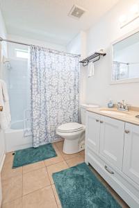 a bathroom with a toilet and a sink and a shower at Surfside Cottage near Navarre Beach in Navarre