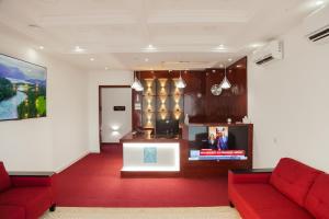 a lobby with two red couches and a tv at Hotel Totara in Dar es Salaam