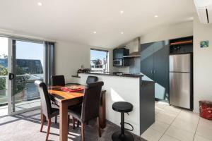 a kitchen and dining room with a table and chairs at Longbeach Ocean Paradise in Mount Maunganui