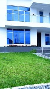 een wit gebouw met een groen gazon ervoor bij Contemporary 4-Bedroom Villa with VR Room and Starlink Internet - Ifemide Estates in Akure