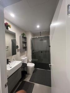 a bathroom with a shower and a toilet and a sink at Ruckers Hill Northcote Penthouse in Melbourne