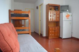 sala de estar con nevera, cama y cocina en Departamento en Villa Gesell en Villa Gesell