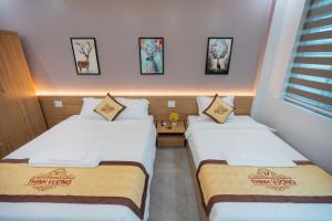 duas camas num pequeno quarto com duas em HoTel Thịnh Vượng em Dien Bien Phu