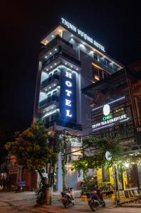 un bâtiment avec un panneau bleu sur son côté dans l'établissement HoTel Thịnh Vượng, à Diện Biên Phủ