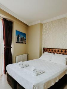 a bedroom with a large bed with two towels on it at Punta Vista Otel in İzmir