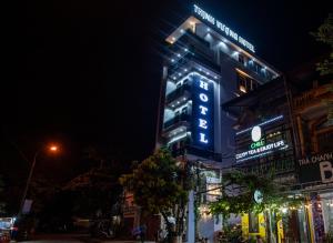 Un edificio con un cartel en la noche. en Thịnh Vượng HoTel, en Diện Biên Phủ