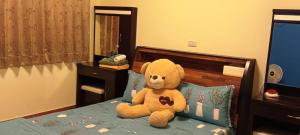 a teddy bear sitting on top of a bed at 988 Ancient House B&B in Jincheng