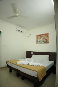 uma cama num quarto branco com em Padmatheertham Inn em Varkala