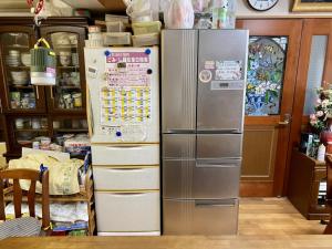 a refrigerator in a kitchen with a stack of boxes at Guest in Shallman in Amami