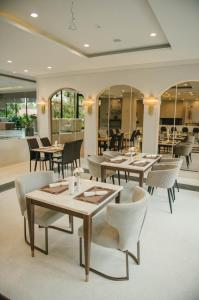 una sala da pranzo con tavoli, sedie e finestre di Carrara Hotel Hatyai a Hat Yai