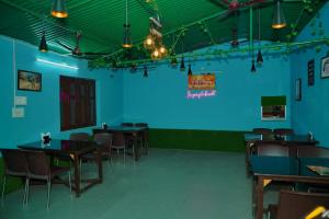 a room with tables and chairs and a blue wall at Shri Jai Krishna Homestay in Rāmnagar