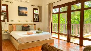 Un dormitorio con una cama en una habitación con ventanas. en Tropical garden, en Phuket 13 fotos más