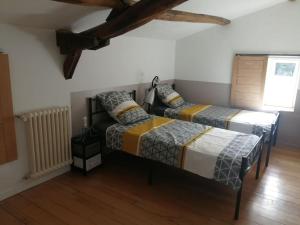 Un dormitorio con dos camas y una ventana. en maison pleine de charme, en Saint-Étienne-de-Mer-Morte