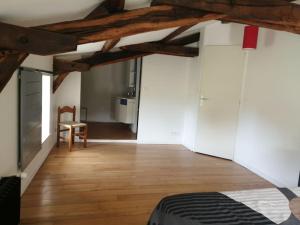 Habitación con cama y suelo de madera. en maison pleine de charme, en Saint-Étienne-de-Mer-Morte 1 foto más