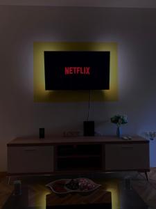 a television with a netflix sign on a wall at Stan na dan - Apartmani Q in Doboj