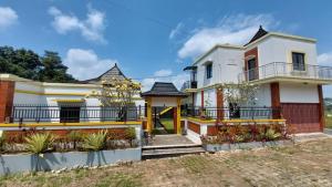 a white house with a gate and fence at Pool Villa Saung Suluh in Purwokerto