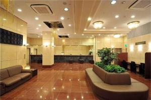 eine Lobby mit Sofas und Pflanzen in einem Gebäude in der Unterkunft Okayama Universal Hotel Annex 2 in Okayama