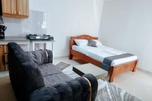 ein Wohnzimmer mit einem Bett und einem Sofa in der Unterkunft Premier Stays Ruiru in Ruiru