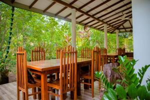a wooden table and chairs under a pergola at Nehansa Resort and safari in Tissamaharama