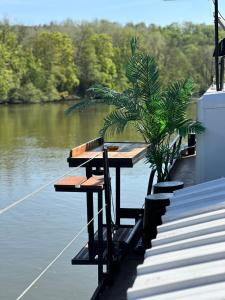 una mesa de picnic a un lado de un barco en un río en Studio sur la péniche Santa Julia à Chantilly Insolys, en Saint-Leu-dʼEsserent
