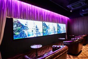 a room with purple curtains and a large screen at Petit Bali Ikebukuro in Tokyo