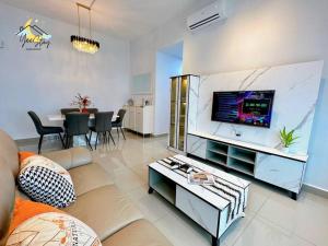a living room with a couch and a flat screen tv at Amber Cove 7pax/VideoGame/5min to Jonker in Melaka