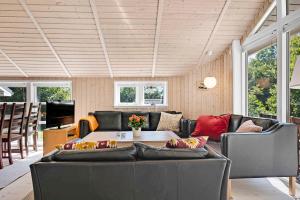 ein Wohnzimmer mit einem Sofa und einem Tisch in der Unterkunft Sommerhus I Brunshuse in Hårby