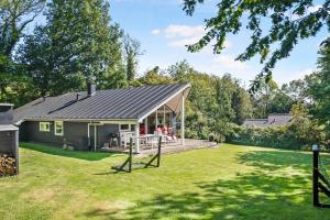 ein kleines Haus mit einer Veranda und einem Hof in der Unterkunft Sommerhus I Brunshuse in Hårby