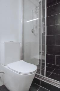 a white toilet in a bathroom with a shower at Cosy studio with a big view in Sydney