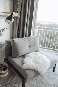 a chair with a white furry pillow sitting in front of a window at Cosy studio with a big view in Sydney