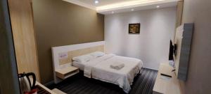 a hotel room with a bed and a television at Nest Dayroom, 12hours stay in Bandar Seri Begawan