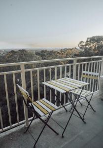 uma mesa e uma cadeira numa varanda com o oceano em Cosy studio with a big view em Sydney