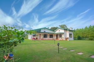 una casa con césped delante en SaffronStays The Lodge at Dalewal, Hoshiarpur en Hoshiārpur