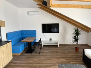 a living room with a blue couch and a table at Aquarius 12 Stawy Walczewskiego in Grodzisk Mazowiecki