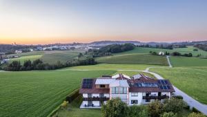 una casa con paneles solares en un campo en Pension Ambros en Büchlberg