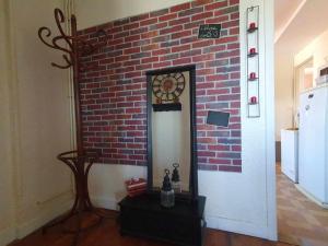 a room with a brick wall with a clock on it at Spacieux - LITERIE HAUT DE GAMME - Billard - Fléchette -TV 65" - Netflix - Amazon Prime- LIT KING SIZE - 4 chambres - Jeux enfants - Terrasse - Barbecue - Géré par Presta-Zen'Services- Chez Aline in Verdun