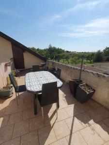 a patio with a table and chairs on a balcony at Spacieux - LITERIE HAUT DE GAMME - Billard - Fléchette -TV 65" - Netflix - Amazon Prime- LIT KING SIZE - 4 chambres - Jeux enfants - Terrasse - Barbecue - Géré par Presta-Zen'Services- Chez Aline in Verdun