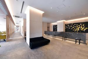 a lobby with a counter and chairs in a building at Vessel Hotel Campana Nagoya in Nagoya